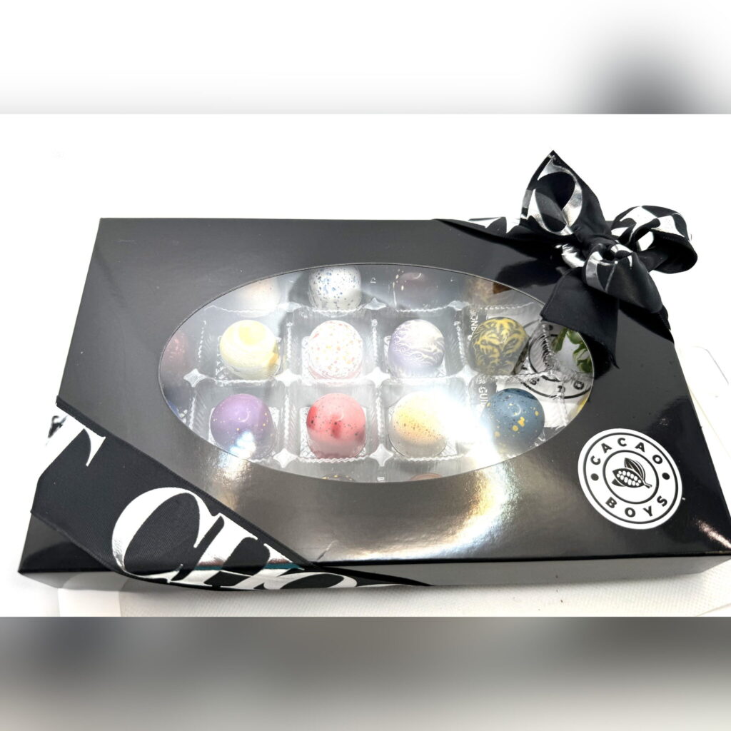 A ribboned Cacao Boys seasonal gift box of assorted bonbons