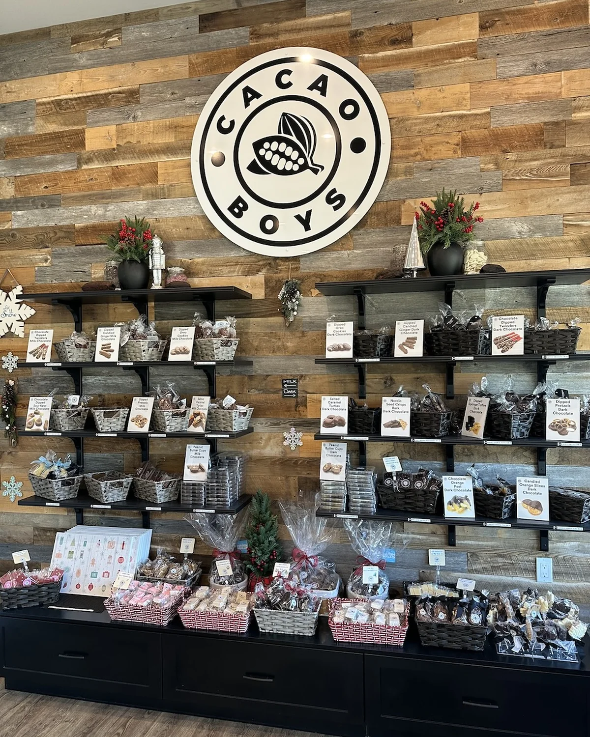 Inside the Cacao Boys shop in Bala, with the logo wall and chocolate shelves